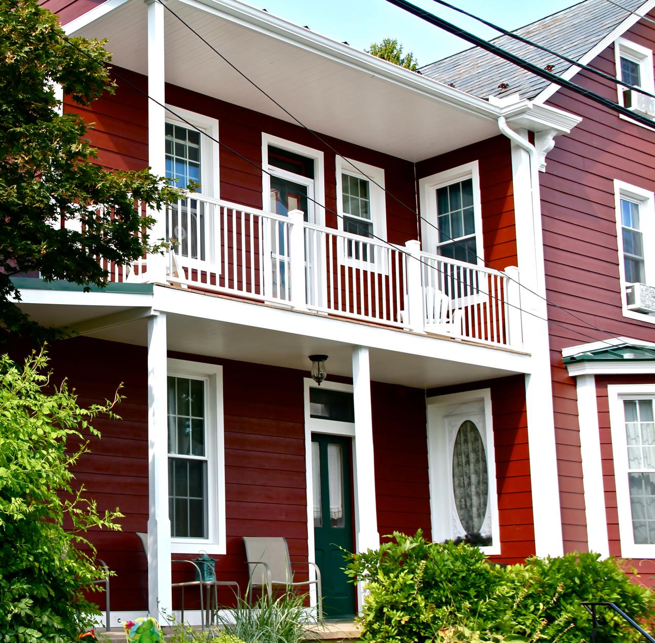 Two story house clad in Countrylane Red Hardie Plank and Arctic White Hardie Trim