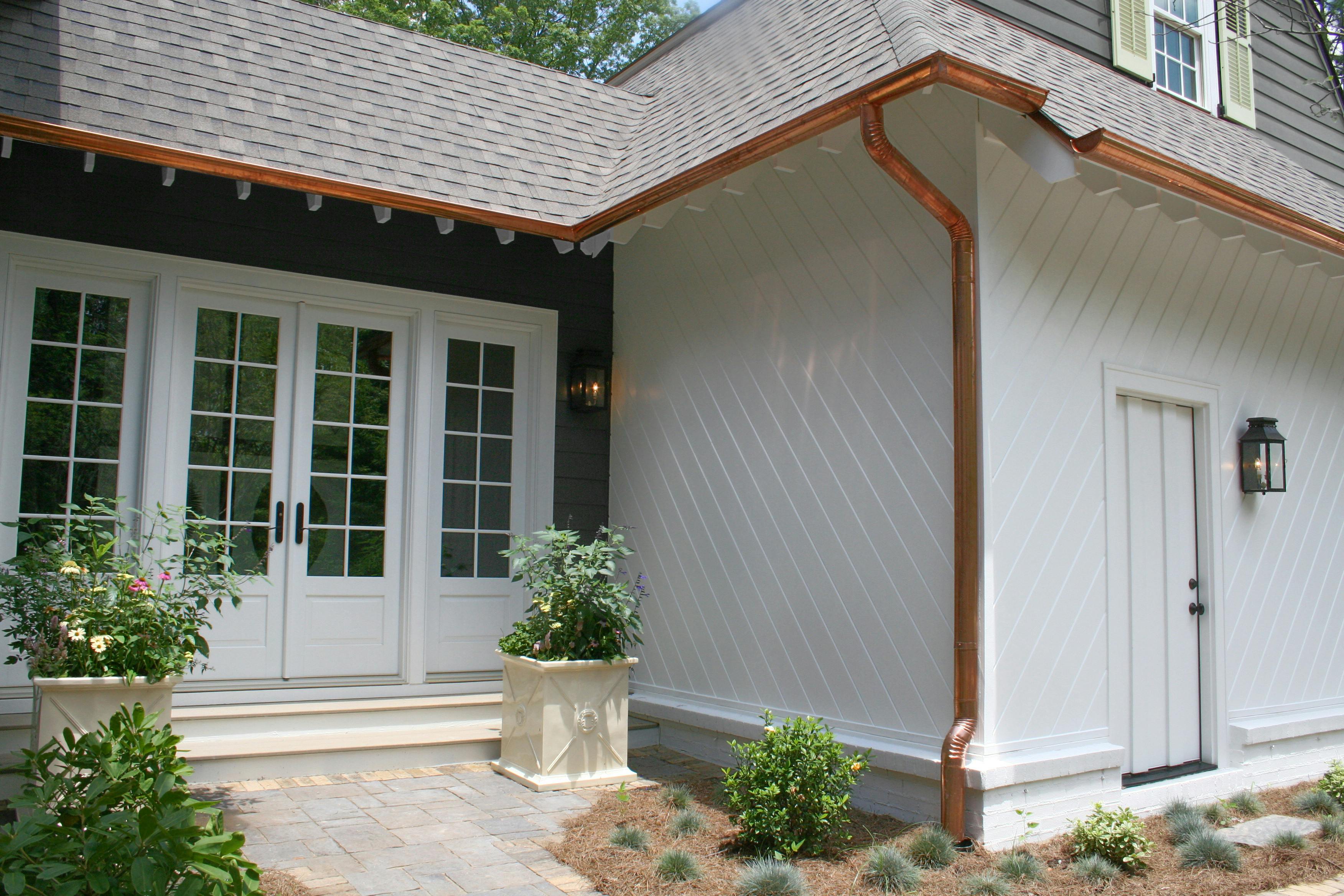 Detail of a home clad in Arctic White and Iron Gray Hardie® Artisan with bright copper rain gutters