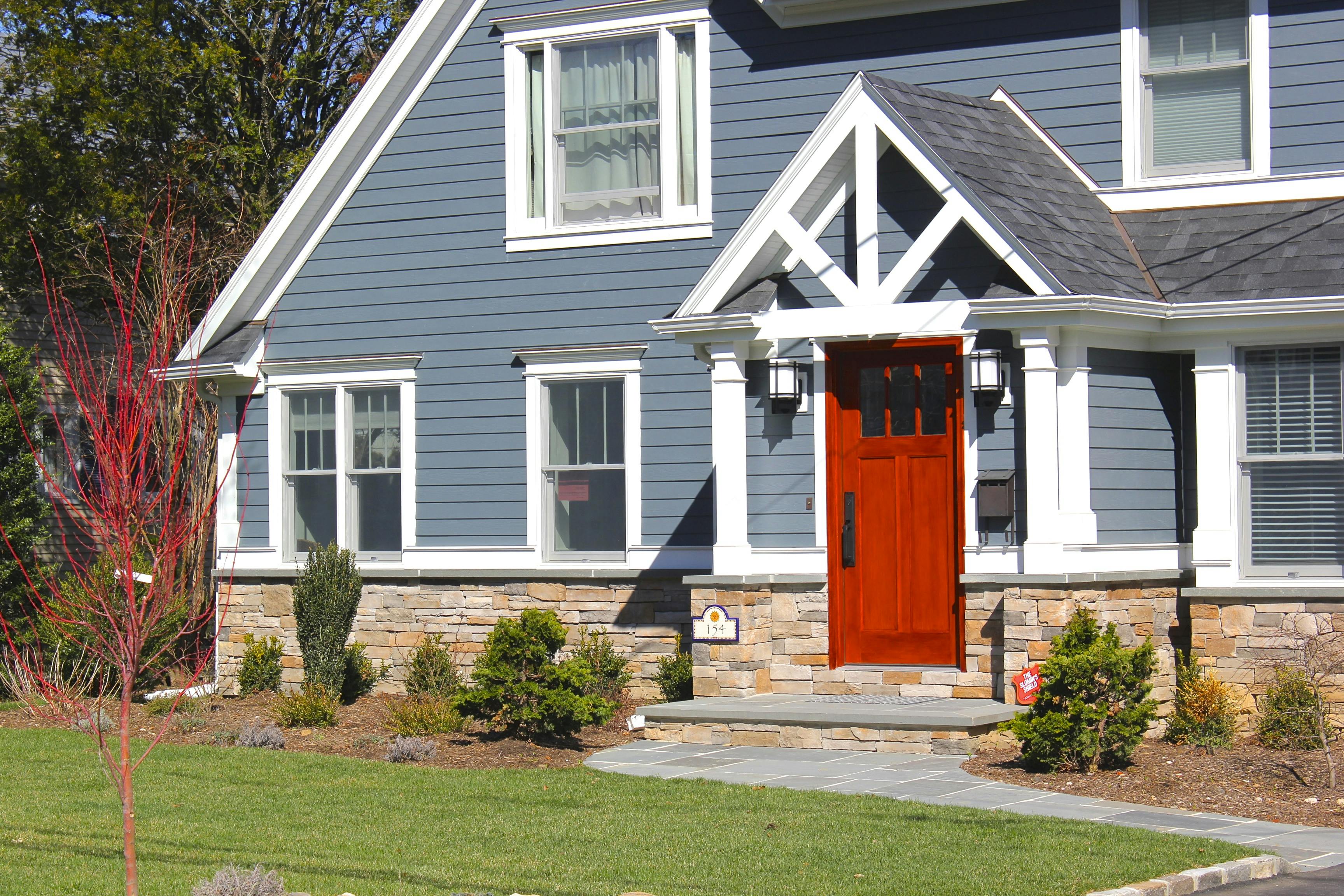 House with Evening Blue Hardie® Plank lap siding and Arctic White Hardie® Trim and a scarlet statement door.