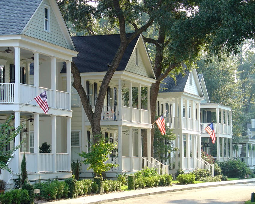 Streetscape of two-story homes with American flags on front porch
