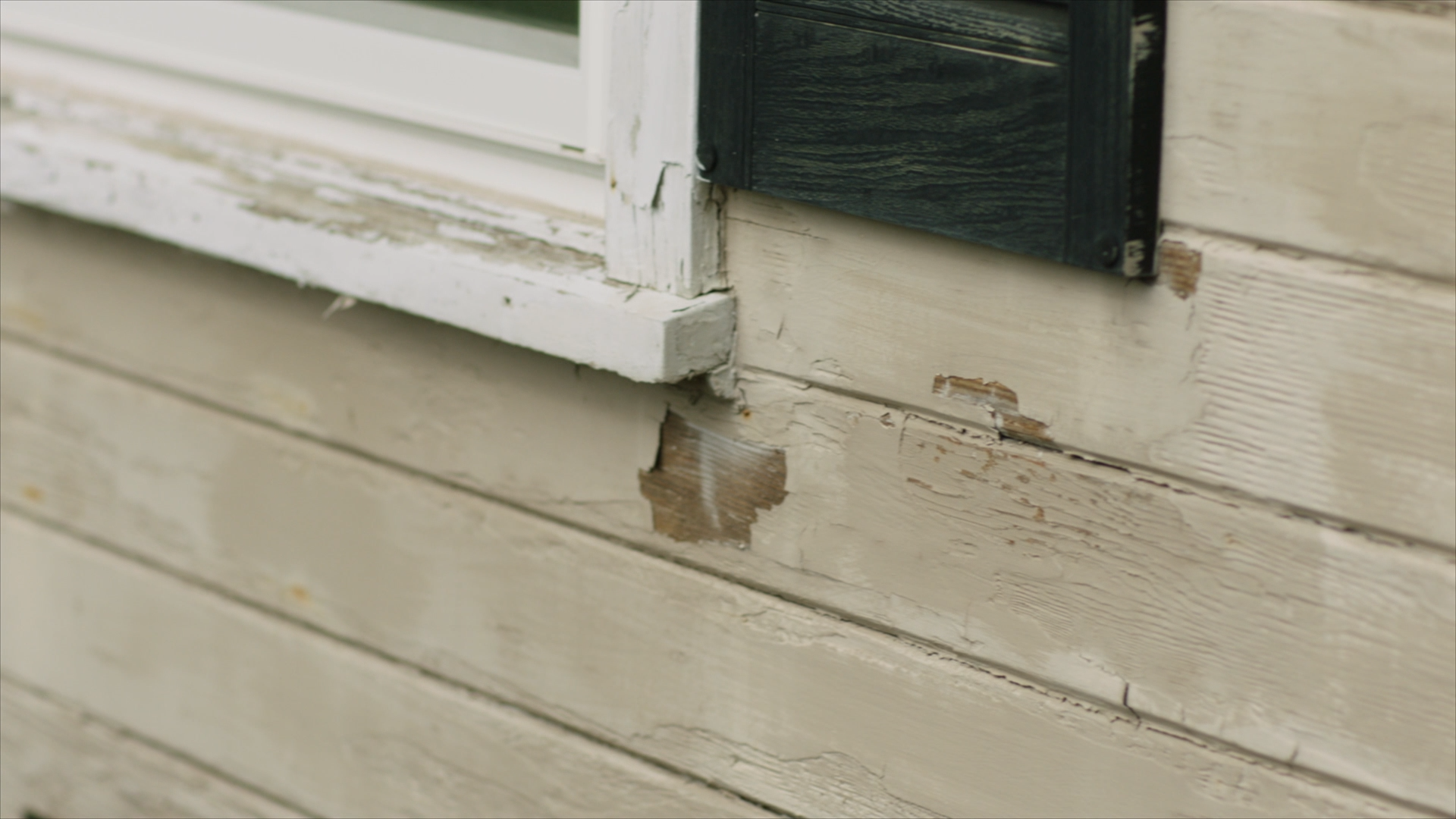 Close-up on wood siding with chipped and peeling paint