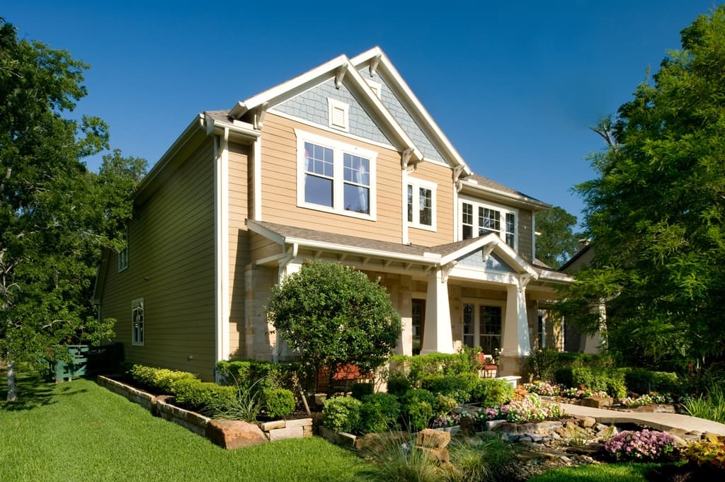 Two story house clad with Hardie® Plank in Fawn and Hardie® Shingle in Light Mist