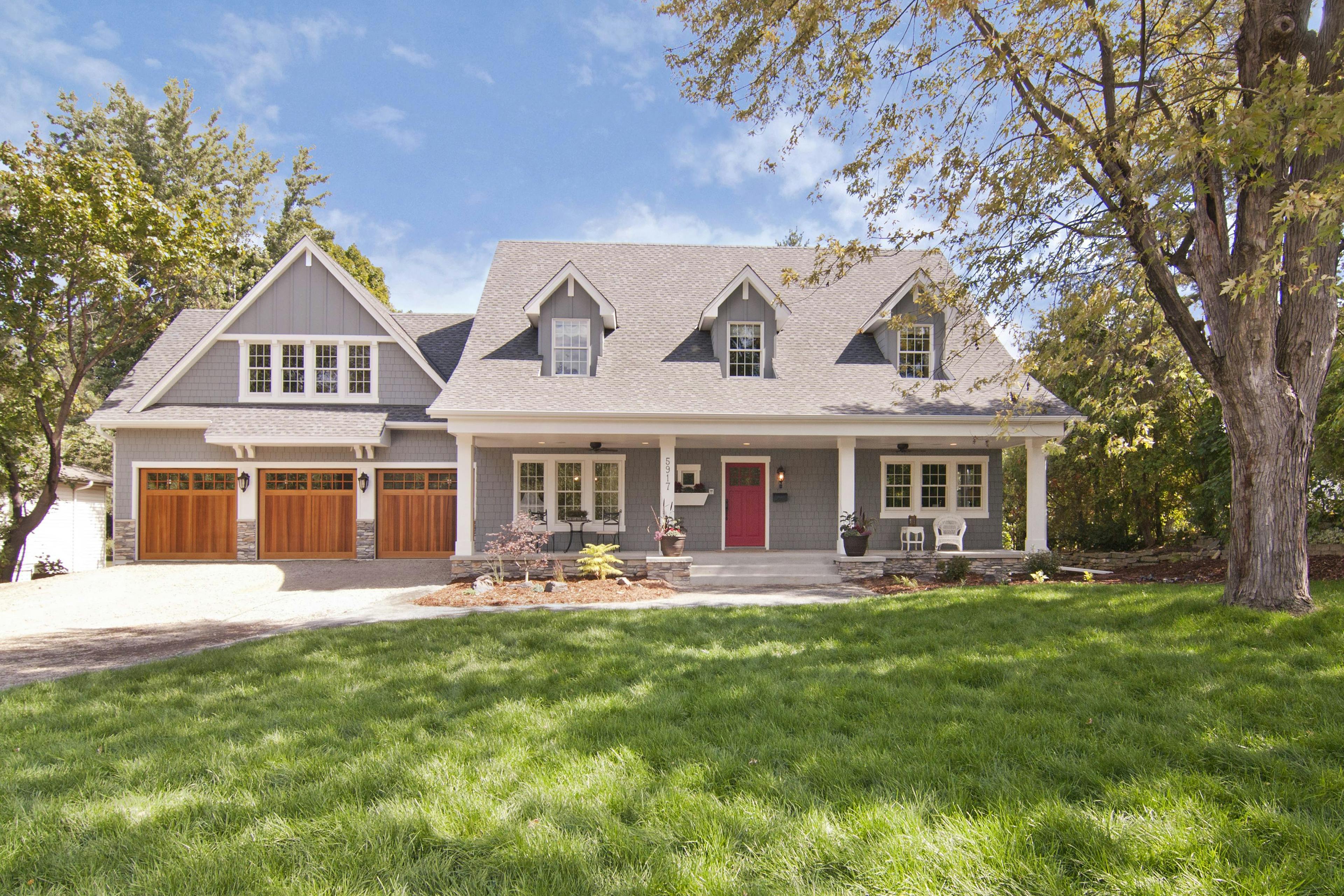 A traditional Cape Cod home with gray plank lap siding and white trim