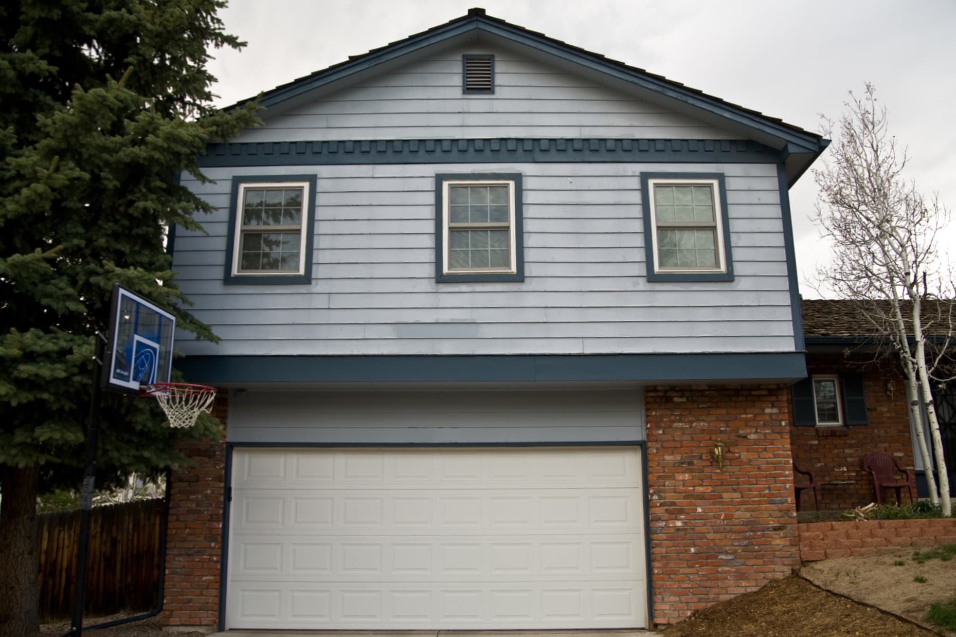 Decide to Re-side: Front of home with wood siding, showcasing cracked boards and peeling paint Front of home with wood siding, showcasing cracked boards and peeling paint